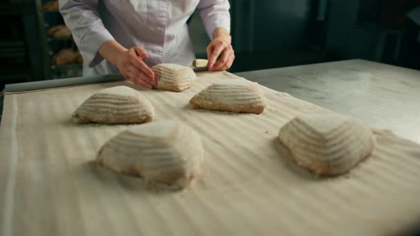 Kobieta Piekarz Tnie Wzory Surowych Bułkach Chlebowych Profesjonalnym Nożem Piekarskim — Wideo stockowe