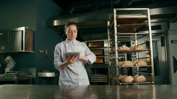Seorang Tukang Roti Wanita Dengan Seragam Dekat Rak Rak Dengan — Stok Video