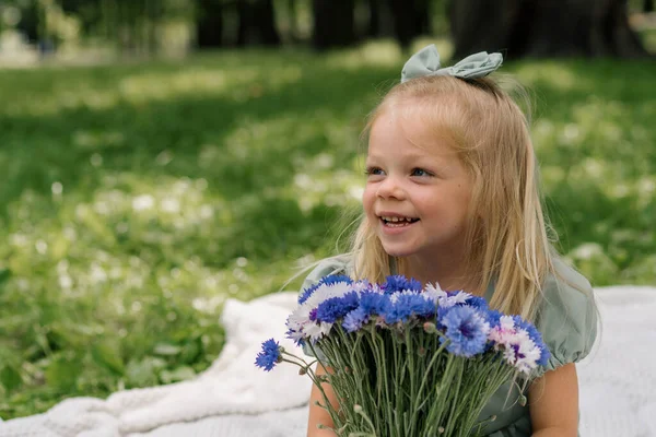 花と公園で休んでいる幸せな少女の肖像画 ケアフリーの子供の夏の日屋外レクリエーション — ストック写真