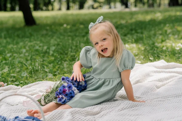 花と公園で休んでいる幸せな少女の肖像画 ケアフリーの子供の夏の日屋外レクリエーション — ストック写真