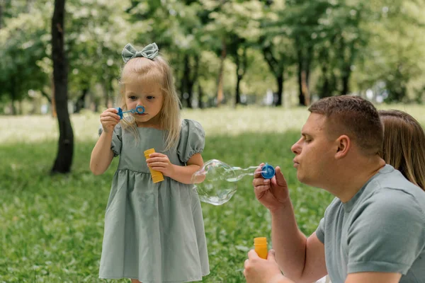Šťastný Rodinný Odpočinek Venku Parku Táta Dcera Foukání Mýdlové Bubliny — Stock fotografie