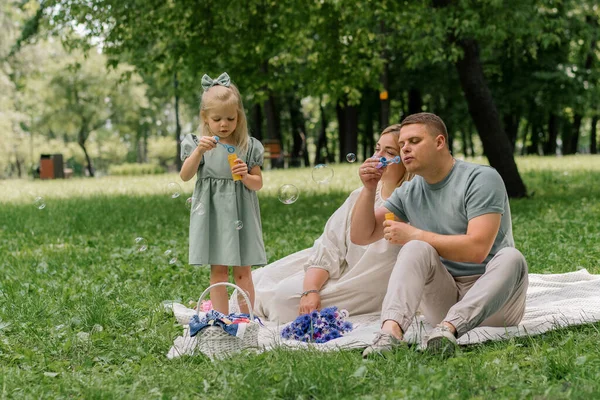 快乐的家庭在公园里放松一下爸爸和女儿吹泡泡肥皂泡快乐的童年家庭周末 — 图库照片
