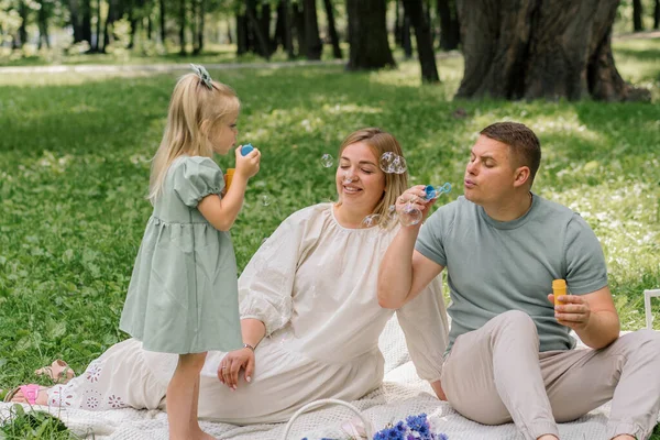 快乐的家庭在公园里放松一下爸爸和女儿吹泡泡肥皂泡快乐的童年家庭周末 — 图库照片