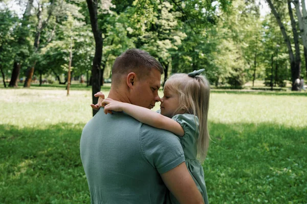 幸せな家族 若い父親は 公園の父の日にお互いに屋外で抱き合う彼の腕の父と娘を抱いている — ストック写真