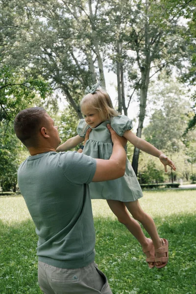 公園で子供と遊ぶ父親は子供と遊ぶ空の幸せな家族の日ファミリーで娘を投げます — ストック写真