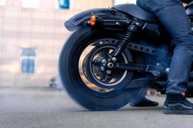 Motorsiklet tekerleğinin kapağını kapat. Lastik yak. Spor bir motosiklet yarışının tekerlerinden çıkan duman ve kıvılcımlar.