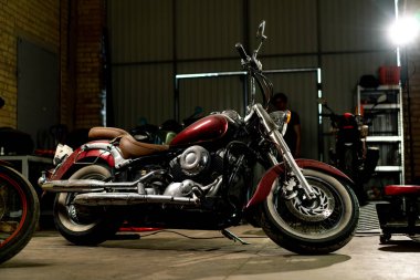 Otantik motosiklet atölyesi. Tamirden önce garajda güzel, modern bir motosiklet duruyor.