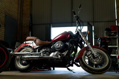 Otantik motosiklet atölyesi. Tamirden önce garajda güzel, modern bir motosiklet duruyor.