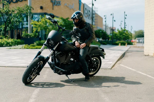 头戴安全帽 身穿皮夹克的严肃的自行车手在比赛前骑着黑色摩托车在街上狂奔 — 图库照片