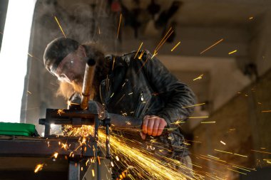 Yaratıcı otantik motosiklet atölyesi kızıl sakallı vahşi motorcu sıcak metalden kıvılcımlar saçıyor.