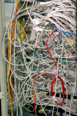 Bir veri merkezindeki sunucu rafındaki yama panelinden bir raf dolusu ağ yama kablosunun sıralanması