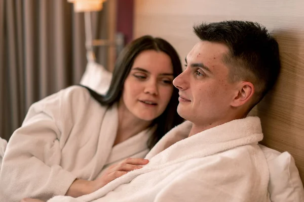 Portrait Young Couple Honeymoon Hotel Room Lying Bed White Robes — Stock Photo, Image