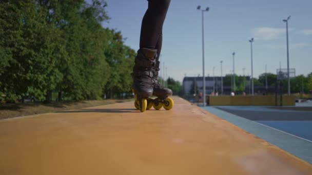 在公园城市背景下练习轮滑技巧的女运动员喜欢轮滑课近腿街头运动 — 图库视频影像