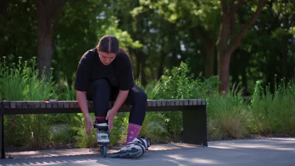 若いヒップスターガールは スケートパークでローラースケートを着用し スケートストリート極端なスポーツを開始する前に — ストック動画