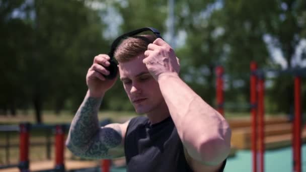 Portret Młodego Spoconego Sportowca Tatuażami Kolczykami Słuchawkach Boisku Sportowym Trening — Wideo stockowe