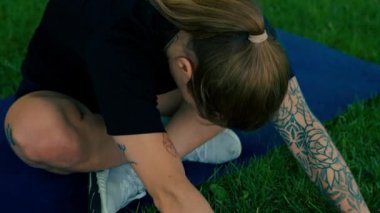 Spor yapan genç kızın portresi. Spor minderinde yoga yaparken park sağlıklı yaşam tarzı kavramını geliştiriyor.