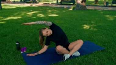 Spor yapan genç kızın portresi. Spor minderinde yoga yaparken park sağlıklı yaşam tarzı kavramını geliştiriyor.