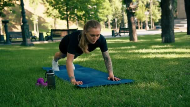 年轻而满意的女运动员在户外做俯卧撑练习的肖像 在公园健康生活方式概念下运动时从疲劳垫子中躺下 — 图库视频影像