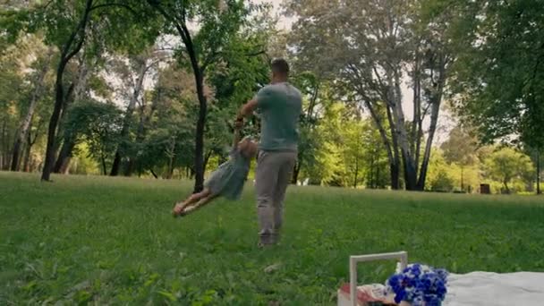 爸爸和一个孩子在公园里玩耍 把他的女儿扔到天上快乐的家庭父亲节家庭和孩子一起玩耍 — 图库视频影像