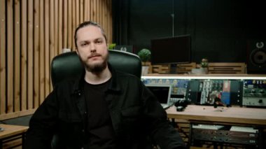Genç ciddi ses mühendisinin portresi profesyonel ev müziği kayıt stüdyosu şarkı kaydetmede ustalaşıyor