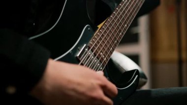 Kayıt stüdyosunda elektro gitarlı bir rock sanatçısı kendi şarkısını çalıyor şarkı enstrümanlarını yaratıyor.