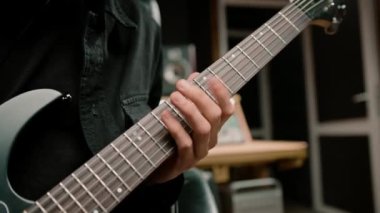 Kayıt stüdyosunda elektro gitarlı bir rock sanatçısı kendi şarkısını çalıyor şarkı enstrümanlarını yaratıyor.