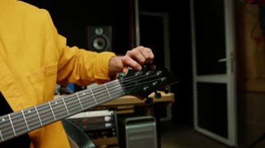 Kayıt stüdyosunda elektro gitarlı bir rock müzisyeni kendi müzik enstrümanlarını çalıyor.