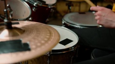 Davulcu profesyonel bir müzisyenin prova stüdyosunda davul çalar. Bir şarkı enstrümanın yakın çekimini geçer.