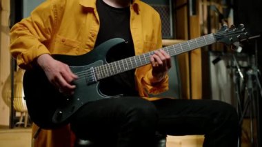 Kayıt stüdyosunda elektro gitarlı bir rock sanatçısı kendi şarkısını çalıyor şarkı enstrümanlarını yaratıyor.