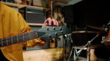 Kayıt stüdyosunda elektro gitarlı bir rock sanatçısı kendi şarkısını çalıyor şarkı enstrümanlarını yaratıyor.