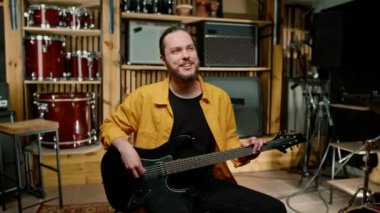Kendi müzik enstrümanını çalan, elektro gitarlı genç bir rock sanatçısının portresi.