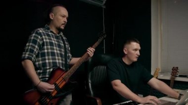Elektro gitar kayıt stüdyosu ile rock sanatçısı ses mühendisiyle kendi şarkısını çalıyor.