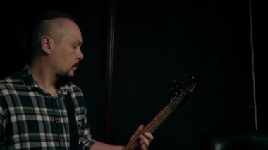 Elektro gitar kayıt stüdyosu ile rock sanatçısı ses mühendisiyle kendi şarkısını çalıyor.