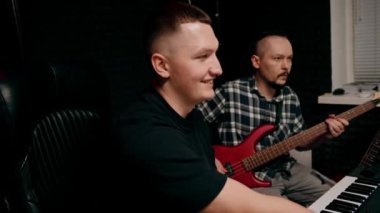 Elektro gitar kayıt stüdyosu ile rock sanatçısı ses mühendisiyle kendi şarkısını çalıyor.