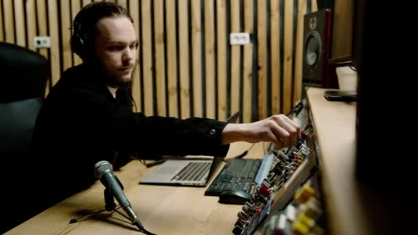 Ung Ljudtekniker Med Hörlurar Som Arbetar Musikstudio Med Bildskärmar Och — Stockvideo