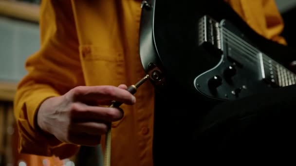 스튜디오에서 기타를 연주자는 악기를 철사와 연결합니다 — 비디오