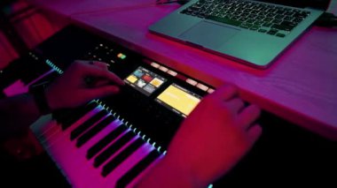 profesyonel kayıt stüdyosu ses mühendisi müzik yapımcısı sentezleyici tuşlarına basan müzisyen kırmızı neon ışığı