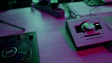 Profesyonel ses kayıt stüdyosu ses mühendisi ya da müzik yapımcısı uzaktan kumandada oturup, ekrandaki neon ışıkları karıştırıyor.