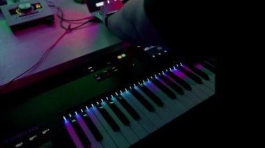 Profesyonel ses kayıt stüdyosu ses mühendisi ya da müzik yapımcısı uzaktan kumandada oturup, ekrandaki neon ışıkları karıştırıyor.