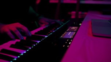 profesyonel kayıt stüdyosu ses mühendisi müzik yapımcısı sentezleyici tuşlarına basan müzisyen kırmızı neon ışığı