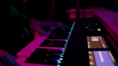 profesyonel kayıt stüdyosu ses mühendisi müzik yapımcısı sentezleyici tuşlarına basan müzisyen kırmızı neon ışığı