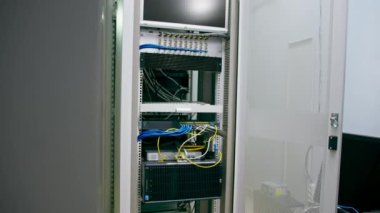 Bir sürü yama ağı kablosu veri merkezi internet depolama odasındaki bir sunucu rafındaki yama panelinden sıralanmış.