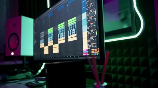 专业的录音室录音工程师或音乐制作人坐在遥控的屏幕霓虹灯混合轨道上 — 图库视频影像