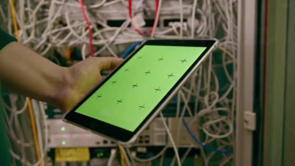 データセンターのクローズアップハッカーまたはグリーンスクリーンタブレットを保持しているエンジニアは サーバーのクラウドストレージ技術から情報を盗みます — ストック動画