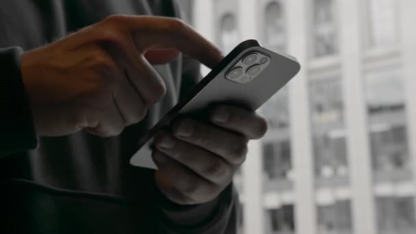 Człowiek Telefonem Rękach Rozwiązuje Problemy Biznesowe Tle Okna Widokiem Centrum — Wideo stockowe