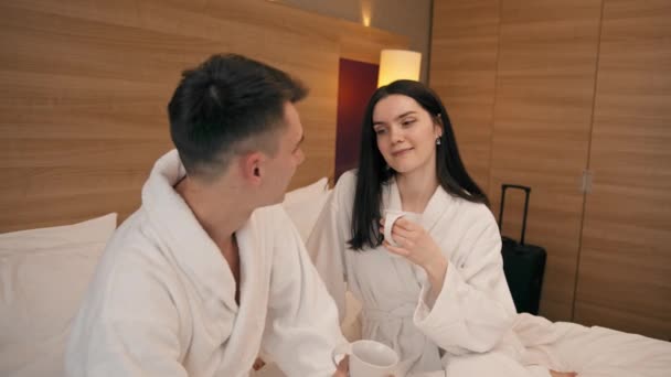 一对年轻夫妇在宾馆房间里共进早餐喝咖啡快乐情侣旅行的理念 — 图库视频影像