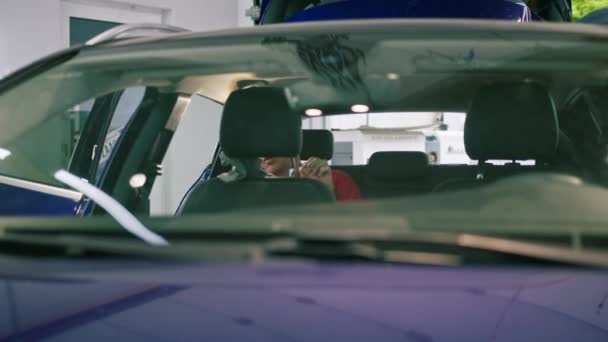詳細な男性カーサービス従業員は マイクロファイバー布でドライクリーニングと洗車インテリアを実行します — ストック動画