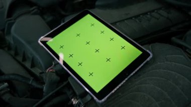 Araba servisinde lüks bir arabanın motorunda duran yeşil ekranın açıldığı tabletin yakın plan görüntüsü