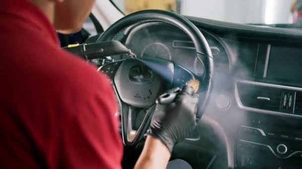 一位洗车工人用抹布 吸尘器和蒸汽机仔细地清扫了一辆豪华汽车的内部 — 图库视频影像