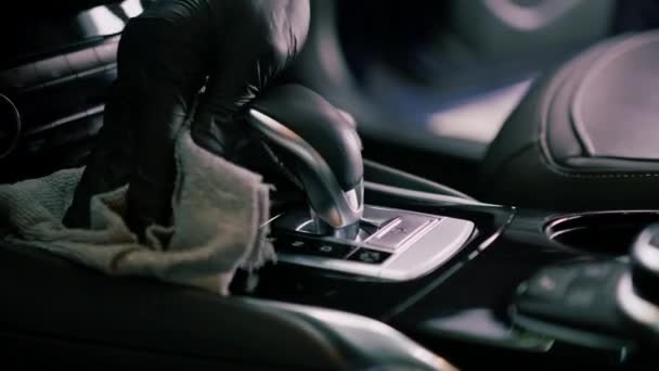 高級車のドライクリーニングと洗濯インテリアを実行する男性カーサービスワーカーの詳細とマイクロファイバー布付きギアセレクター — ストック動画